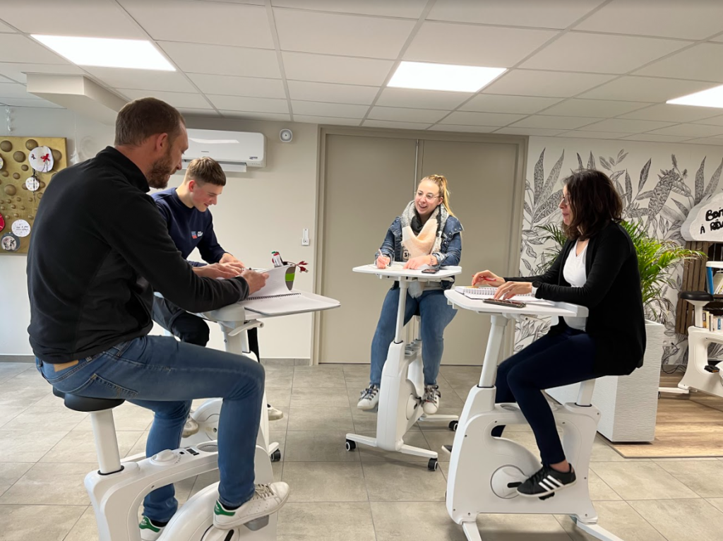 Réunion de collaborateurs souriants et joyeux sur des vélos bureaux.